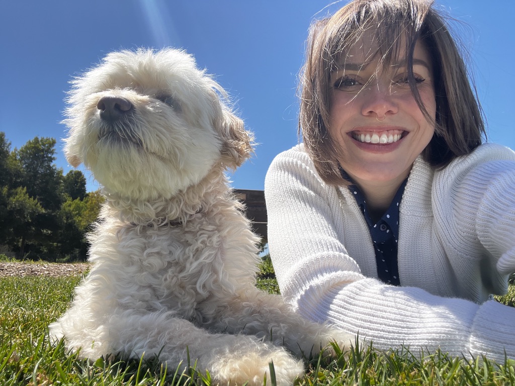 Bree and Crickett the curly-coated dog smiling in the grass